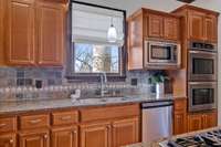 Welcome to this charming kitchen, perfect for culinary enthusiasts and entertainers alike. Featuring double ovens, meal preparation becomes a breeze.  The window above the sink brings in natural light creating an inviting ambiance.