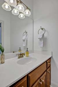 The Jack and Jill bath as two individual vanities, each offering generous counter space, ample cabinetry, and tasteful lighting fixtures.