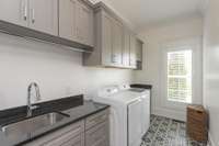 Laundry room on main level with abundant storage and deep stainless steel sink