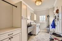 The newly renovated laundry room includes a new tile floor, new cabinets, new oversized stainless steel sink, new stone countertop and fresh paint