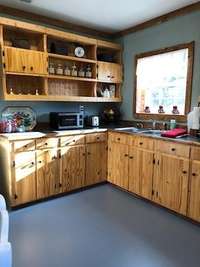 Country kitchen boast natural wood cabinets, a new kitchen sink and hardware