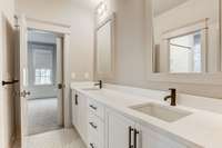 Dual bathroom feature two sinks with plentiful countertop and storage. European black hardware