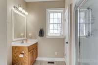 The hidden gem; the full bath behind the laundry room with single vanity and walk in shower; as well as tile flooring.