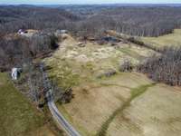 Additional drone photos of the property coming from Shangri Lane, with the Bradford Pears in front, mobile home to the left and the primary home in the far rear.