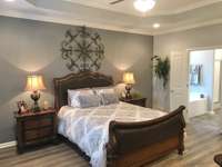 Stock photo of owner's suite with tray ceiling, fan and led recessed lights