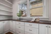 Pantry behind pretty pocket doors, with plenty of counter space, electrical outlets and cabinet/shelving options.