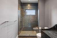 Light filled shower with privacy and poignant design for guests to enjoy.