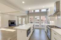 Solid White Oak Wood floors warm up the light cool tones in the kitchen and balance a large, open concept kitchen design.