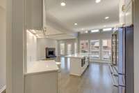 Solid White Oak Wood floors warm up the light cool tones in the kitchen and balance a large, open concept kitchen design.