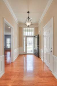 Entry Foyer with Hardwood flooring and crown molding/wainscoting.