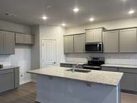 Hampton # 161 - Kitchen features Dallas White Granite countertops and our (optional) Classic Calm Design collection. Single-basin sink and white subway backsplash.