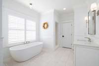 At the center of the bathroom, a large soaking tub beckons, offering a tranquil haven for relaxation.