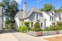 A prominent feature is the rustic stone chimney, rising gracefully from the roof, adding a touch of classic warmth and character.