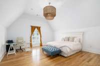 The primary bedroom is the epitome of tranquility and sophistication featuring vaulted ceilings and a shiplap accent wall. The clean lines and white finish of the shiplap create a timeless backdrop that complements the home's aesthetic.