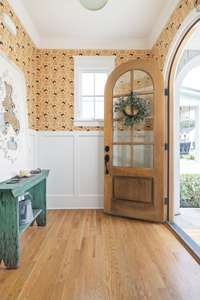 The focal point of this inviting space is the arched door, its rich wooden frame exuding a sense of classic charm.