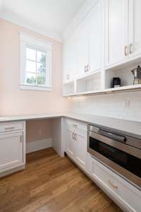 Just off of the kitchen is the prep pantry featuring additional counter space, storage, and a microwave drawer.