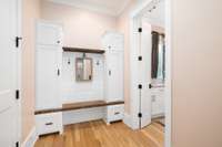 Custom built-in storage solutions dominate the mudroom, offering designated spaces for every item to find its place.