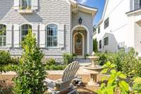A charming front courtyard greets visitors, enhancing the welcoming atmosphere of the home.
