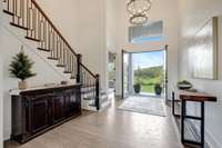 Front entrance bathed in natural light. Double entrance doors. Beautiful staircase with wrought iron spindles and hardwood floors