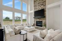 Great room with a 2 story wall of windows and floor to ceiling stone fireplace