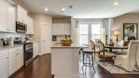 The center island overlooks the dining and living space while adding bar-style seating  *Photo is similar, decorated model home