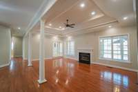 Overlooking the sunroom, this living room provides tons of natural light! Just down the hall, you can see the entrance to one of the full bathrooms, and in the corner past the fireplace is the entrance to the eat in kitchen.