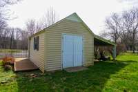 From the back of the shed, you see the extra covered portion to keep things dry. There are also double doors ready to ride your mower on out and keep that lawn green and gorgeous!