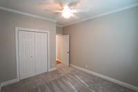 Another view of this bedroom shows the closet, ceiling fan, and the doorway back out next to the first full bathroom.