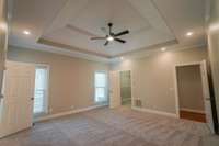 Another view of your primary bedroom shows the walk in closet and door to the hallway. Notice those recessed lights, along with your ceiling fan and large windows! It's like a staycation every night!