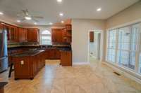 Another view of the kitchen from the living room entrance shows the doorway to the laundry room. Through the laundry room is the door to the garage, and stairway up to the bonus room.