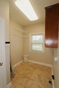 Very functional laundry room with a large closet for cleaning supplies and coats! Cabinets above the washer and dryer and shelves against the wall make laundry a breeze to do in this space!