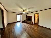 Spacious living room with gas log fireplace and new hardwood flooring - (there is a dumbwaiter cabinet to the left of the fireplace)