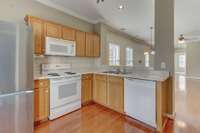 The kitchen offers a pantry, tile backsplash, and stainless steel refrigerator that is included with the home.