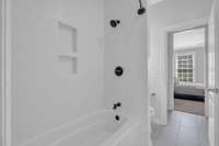 Bright white tub with recessed niches for soaps and shampoos.