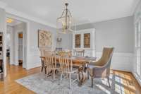 Also flanking the foyer is this pretty formal dining room with floor to ceiling windows and lovely millwork. Note the chandelier that will light your events.