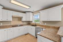 This lovely kitchen is adorned with crisp white cabinetry, new LG appliances, granite countertops and a large, single kitchen sink. The window overlooks your amazing acreage and offers peaceful views of the distant hills!