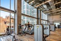 This state-of-the-art main fitness center features Technogym equipment, reclaimed wood floors, exposed brick, and floor-to-ceiling windows