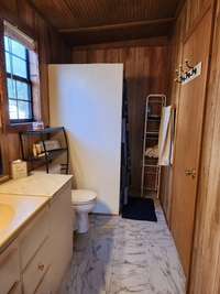 Full bathroom with shower in the back.