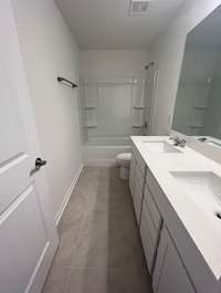Bath #2 includes tile flooring and double sinks with quartz countertops.