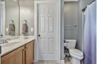 A nice sized bathroom with linen closet and vanity with storage.
