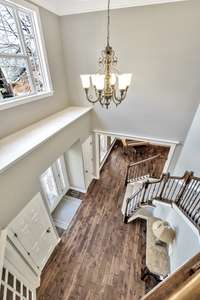 View from the front staircase of the two story entry with newer hardwoods and abundant lighting.