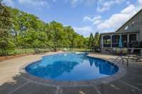 This gorgeous saltwater pool is the centerpiece of he flat backyard, highlighted by a custom firepit and vaulted screened porch.