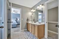 A jack and jill bathroom separate two of the bedrooms with double vanity and shower/tub combination.