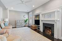 Past the foyer lies the den adorned with its original fireplace—a space ideal for entertaining kids or serving as a secondary living space on the main floor.