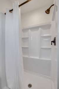 This shower has multiple storage shelves built right in for convenience.