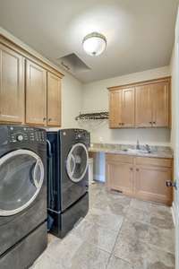 Laundry room has built in cabinets, sink, granite counter tops, and a LAUNDRY CHUTE!!