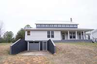 rear view of the home with walkout partial basement.  garage door to store a boat, atvs or lawn equipment