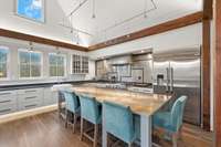 A 10' Moonstone Quartzite island anchors this large kitchen complete with GE Monogram appliances and toe kick LED lighting under all kitchen cabinets, along with LED strip up-lighting.