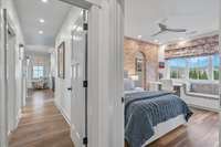 The entry into the primary suite and a look into the second bedroom on the right.  The wall along the hallway includes extra soundproofing.