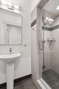 Lower level bathroom features a walk-in shower with custom tile work.